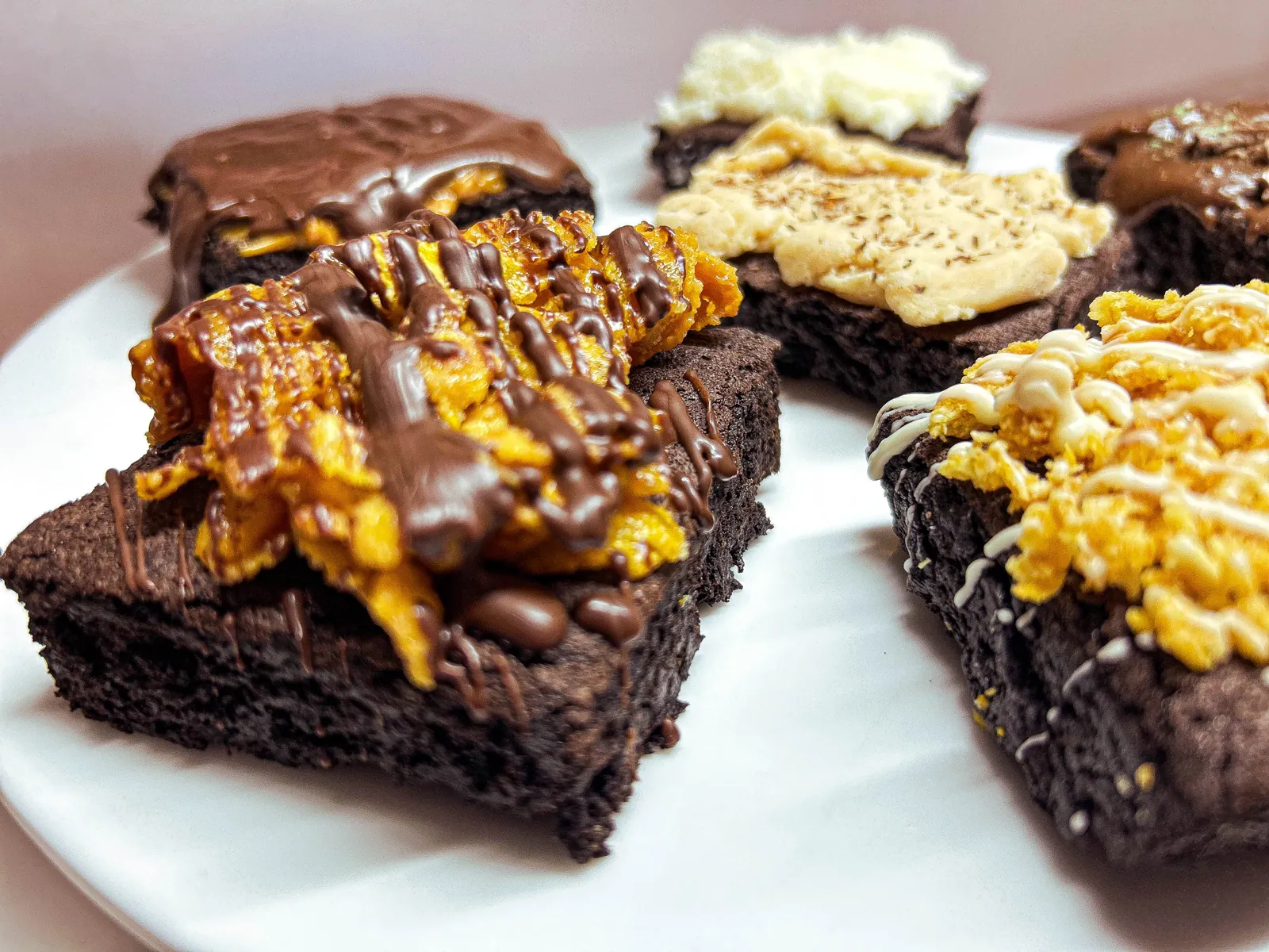 Dark chocolate cornflake crack and millionaire brownies stacked on a plate
