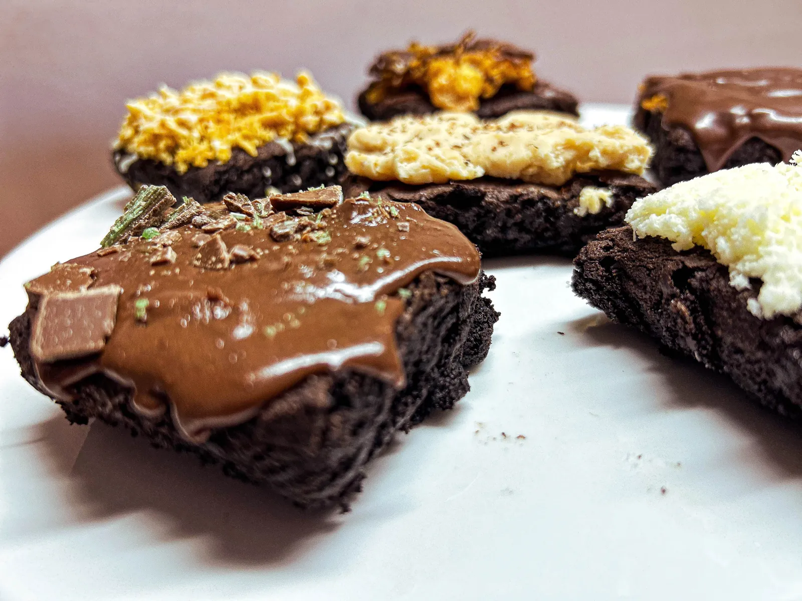 Millionaire brownie with caramel and dark chocolate in front of the flavour range